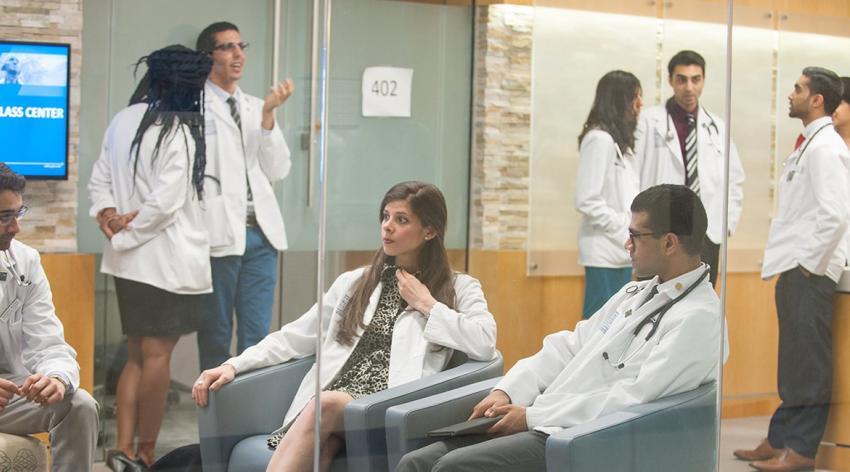 一群穿着白大褂的医科学生在会议中心交谈